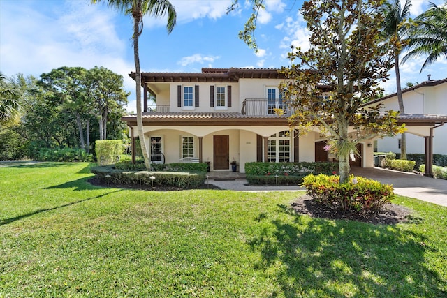 mediterranean / spanish-style home featuring a porch, a balcony, concrete driveway, stucco siding, and a front lawn