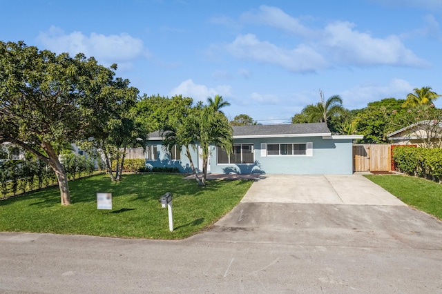 single story home featuring a front lawn, fence, concrete driveway, stucco siding, and a gate