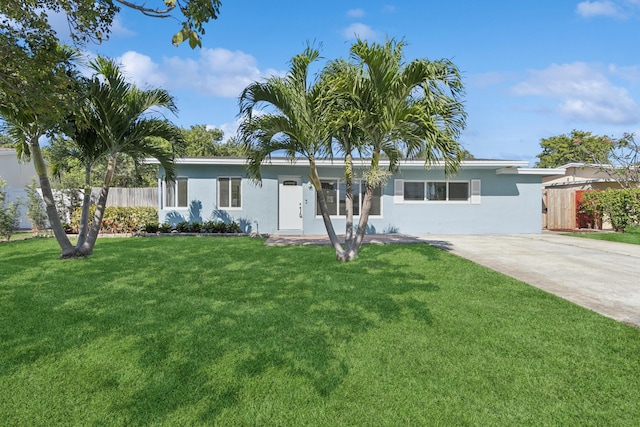 ranch-style home featuring stucco siding, concrete driveway, a front lawn, and fence