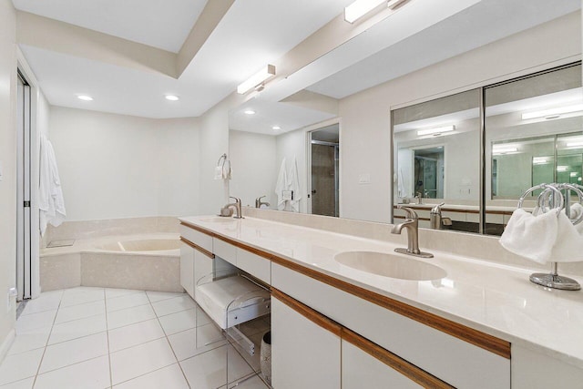 full bathroom with tile patterned flooring, double vanity, a garden tub, and a sink