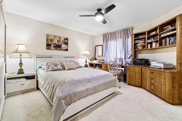 bedroom with light colored carpet, a textured ceiling, and ceiling fan