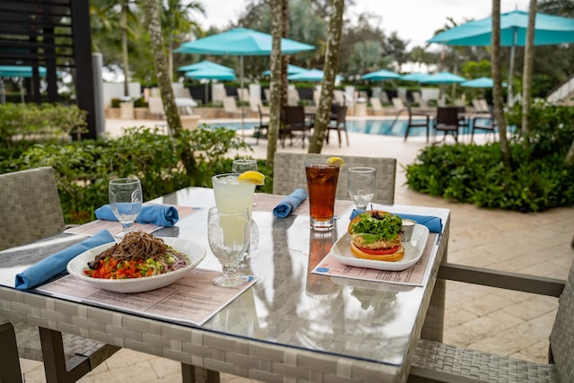 surrounding community featuring outdoor dining area and a patio area