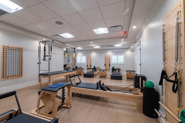 exercise area featuring a drop ceiling, baseboards, visible vents, and wood finished floors