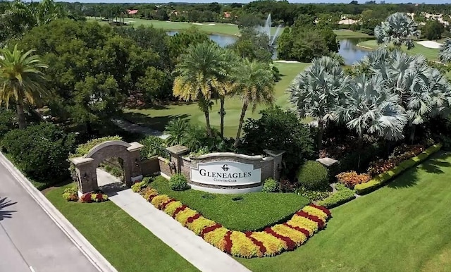 community / neighborhood sign with a yard and a water view