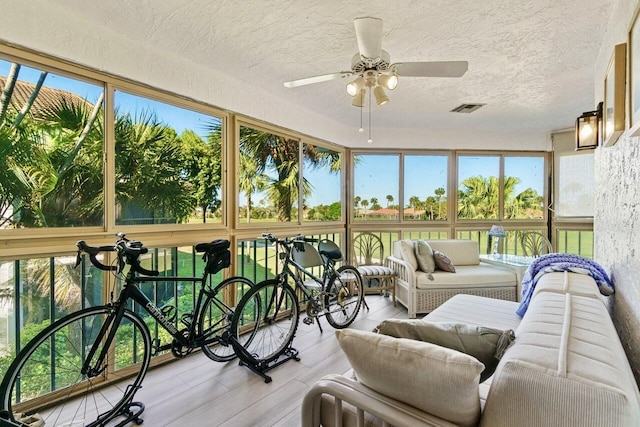 sunroom / solarium with visible vents, plenty of natural light, and a ceiling fan