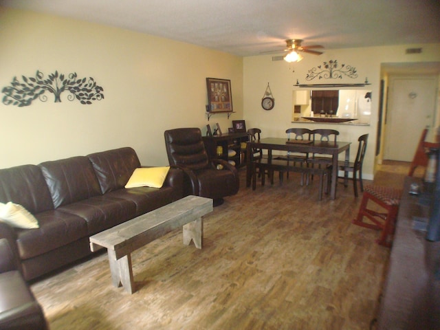 living room with a ceiling fan and wood finished floors