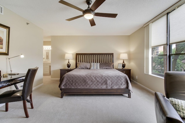 bedroom featuring light colored carpet, a textured ceiling, and baseboards