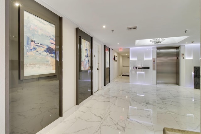 hall with marble finish floor, stone wall, elevator, and recessed lighting