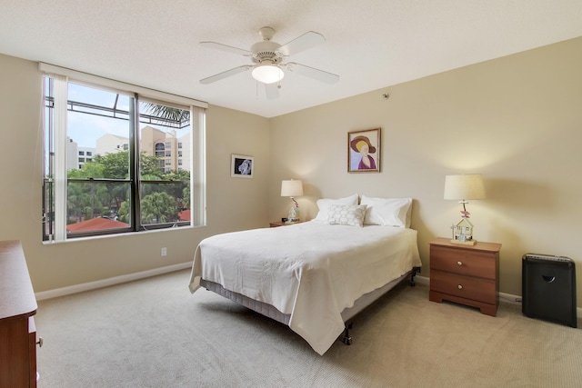 bedroom with baseboards, ceiling fan, and light colored carpet