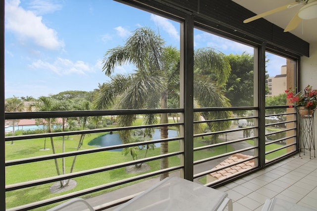 balcony featuring a ceiling fan and a water view