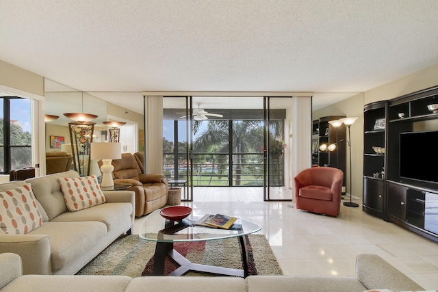 living room featuring ceiling fan and a textured ceiling