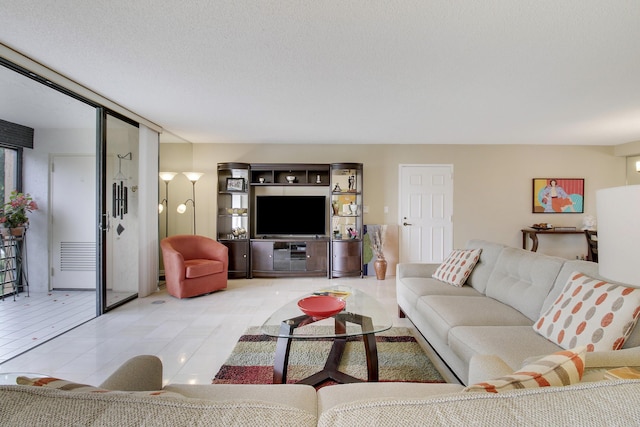 living area featuring a textured ceiling and light tile patterned floors