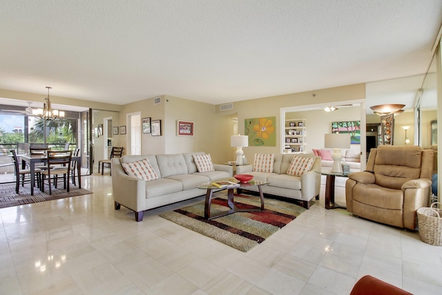 living room with a chandelier, visible vents, and a textured ceiling