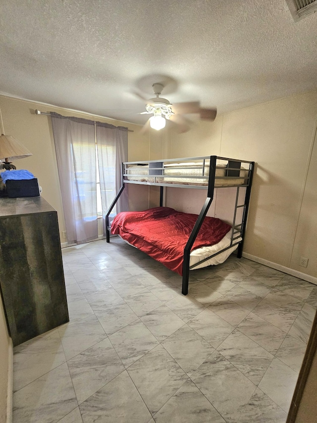 bedroom with ceiling fan, a textured ceiling, and visible vents