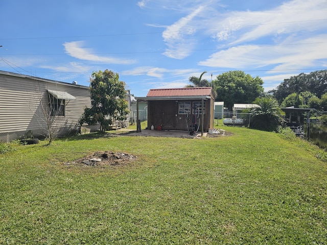 view of yard with a storage shed, an outdoor structure, and fence