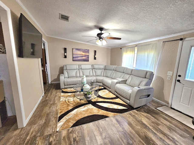 living room with ceiling fan, ornamental molding, wood finished floors, and visible vents