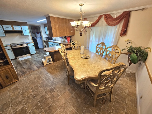 dining space featuring a chandelier and crown molding