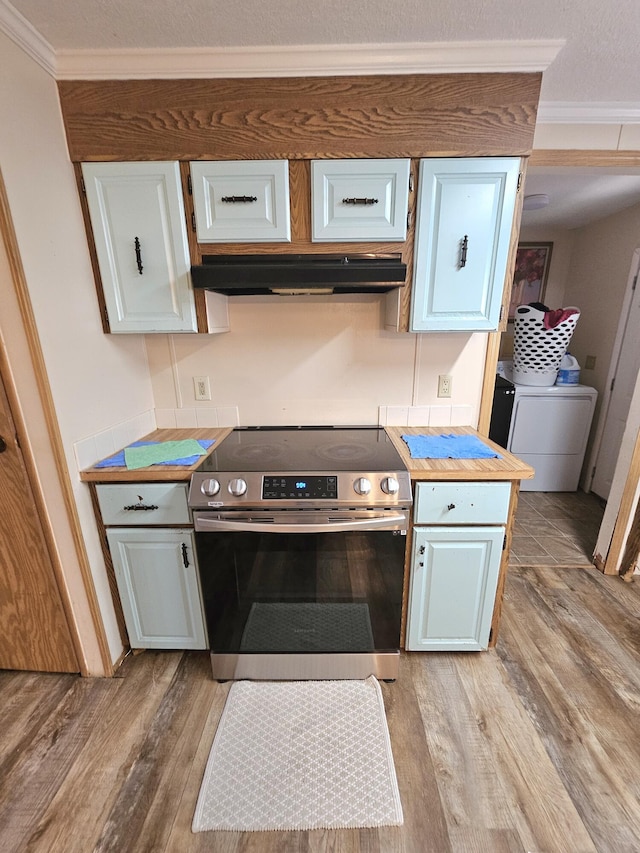 kitchen featuring ornamental molding, wood finished floors, washing machine and clothes dryer, stainless steel electric range, and under cabinet range hood