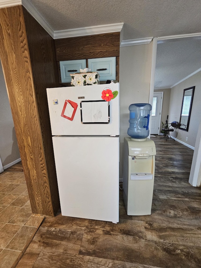 kitchen featuring a textured ceiling, wood finished floors, crown molding, and freestanding refrigerator