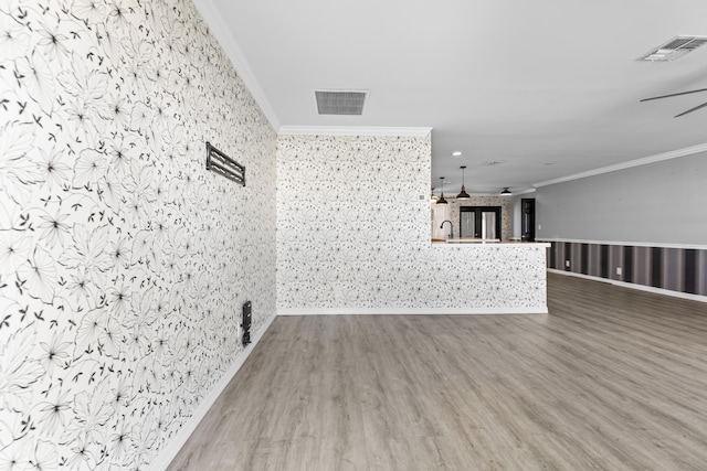 spare room with ceiling fan, visible vents, and ornamental molding