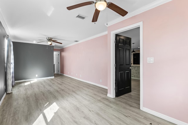 unfurnished room featuring light wood finished floors, visible vents, baseboards, and ornamental molding