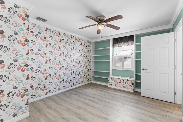 unfurnished bedroom featuring light wood-type flooring, visible vents, ornamental molding, a ceiling fan, and baseboards