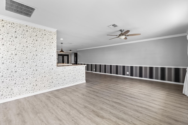 spare room featuring visible vents, wood finished floors, and crown molding