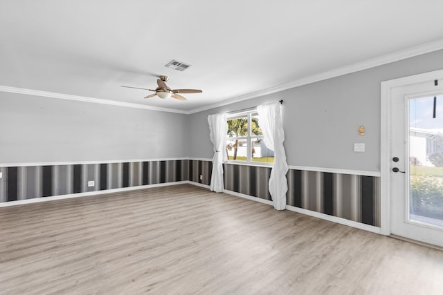 empty room featuring visible vents, crown molding, ceiling fan, and wood finished floors