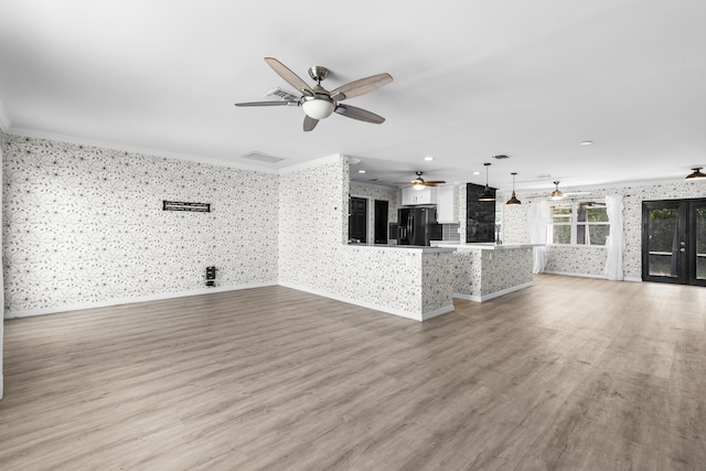 unfurnished living room featuring light wood finished floors, wallpapered walls, baseboards, and ornamental molding