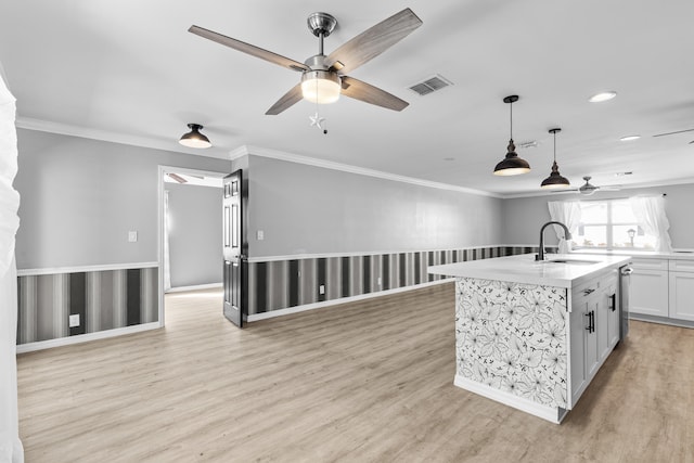 kitchen with a sink, visible vents, open floor plan, and light wood finished floors