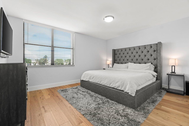 bedroom with light wood-style flooring and baseboards