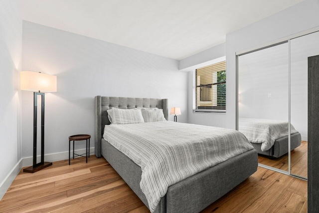 bedroom featuring a closet, baseboards, and wood finished floors