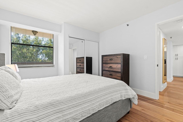 bedroom with a closet, baseboards, and wood finished floors