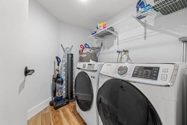 laundry room featuring light wood-type flooring, laundry area, baseboards, and washing machine and clothes dryer