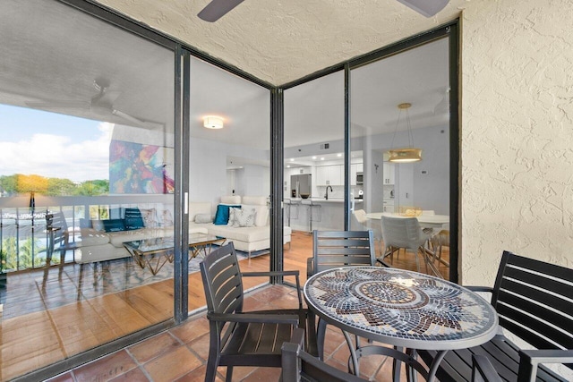 interior space with a textured ceiling, a ceiling fan, and a textured wall