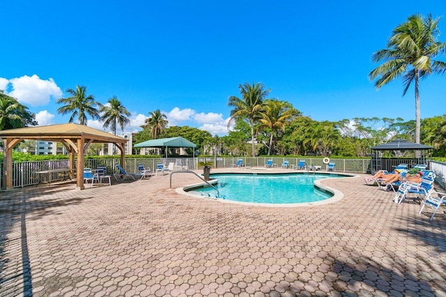 pool featuring a gazebo, a patio, and fence