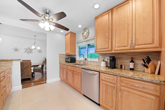 kitchen with light brown cabinetry, a sink, tasteful backsplash, stainless steel dishwasher, and light stone countertops