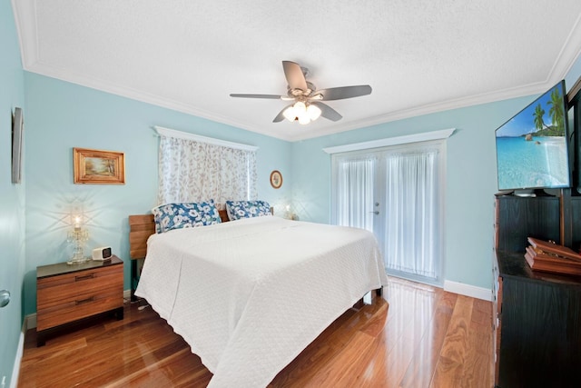 bedroom with ornamental molding, a textured ceiling, wood finished floors, baseboards, and ceiling fan