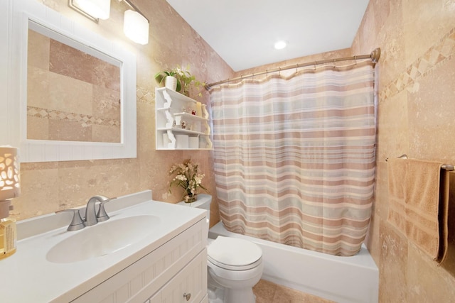 bathroom with toilet, tile walls, shower / bath combo, and vanity