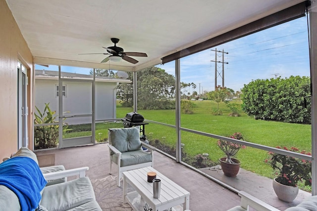 sunroom / solarium featuring a ceiling fan