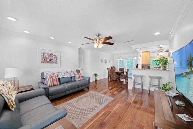 living area featuring light wood-style flooring, crown molding, and ceiling fan