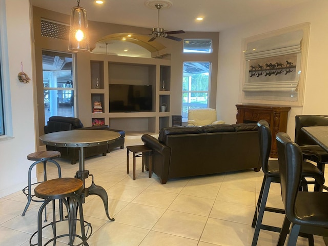 living area with built in shelves, a ceiling fan, recessed lighting, and light tile patterned floors