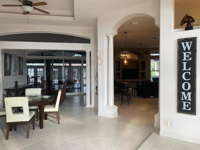 tiled dining area with ceiling fan, arched walkways, and ornate columns