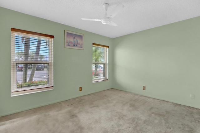 carpeted empty room with a ceiling fan and a textured ceiling