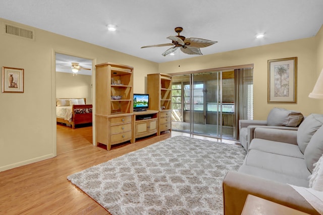 living room featuring light wood-style floors, visible vents, ceiling fan, and baseboards