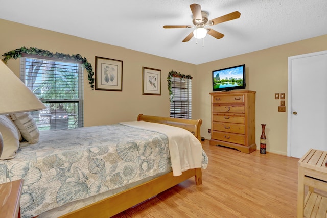 bedroom featuring multiple windows, light wood-type flooring, and a ceiling fan