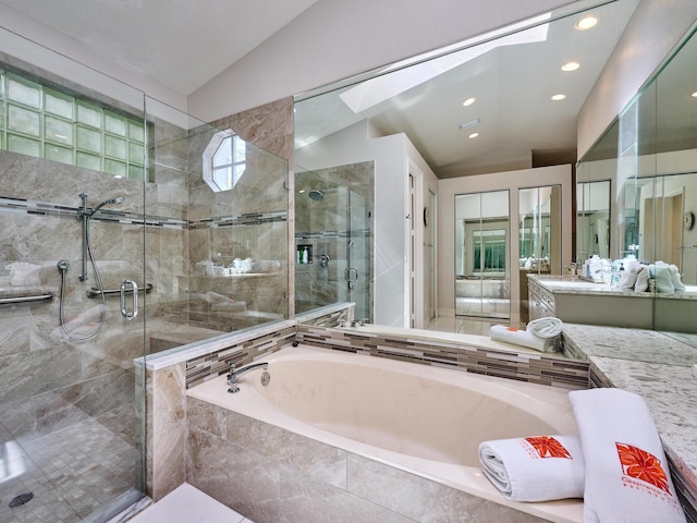 full bath with vanity, lofted ceiling with skylight, a garden tub, and a shower stall