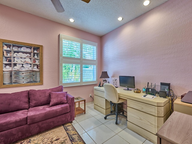 home office featuring light tile patterned floors, a textured ceiling, ceiling fan, and a textured wall