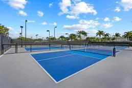 view of tennis court with community basketball court and fence