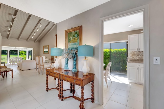 hall with light tile patterned flooring and vaulted ceiling